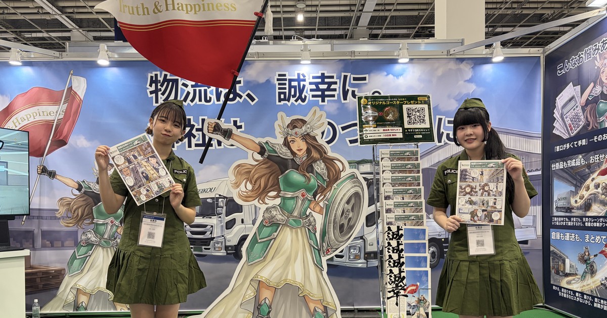 第29回 ものづくり ワールド［大阪］初日の誠幸運輸倉庫さまのブース。旗を掲げる物流の女神セイコの等身大パネルと、マンガを持つ衣装のスタッフ