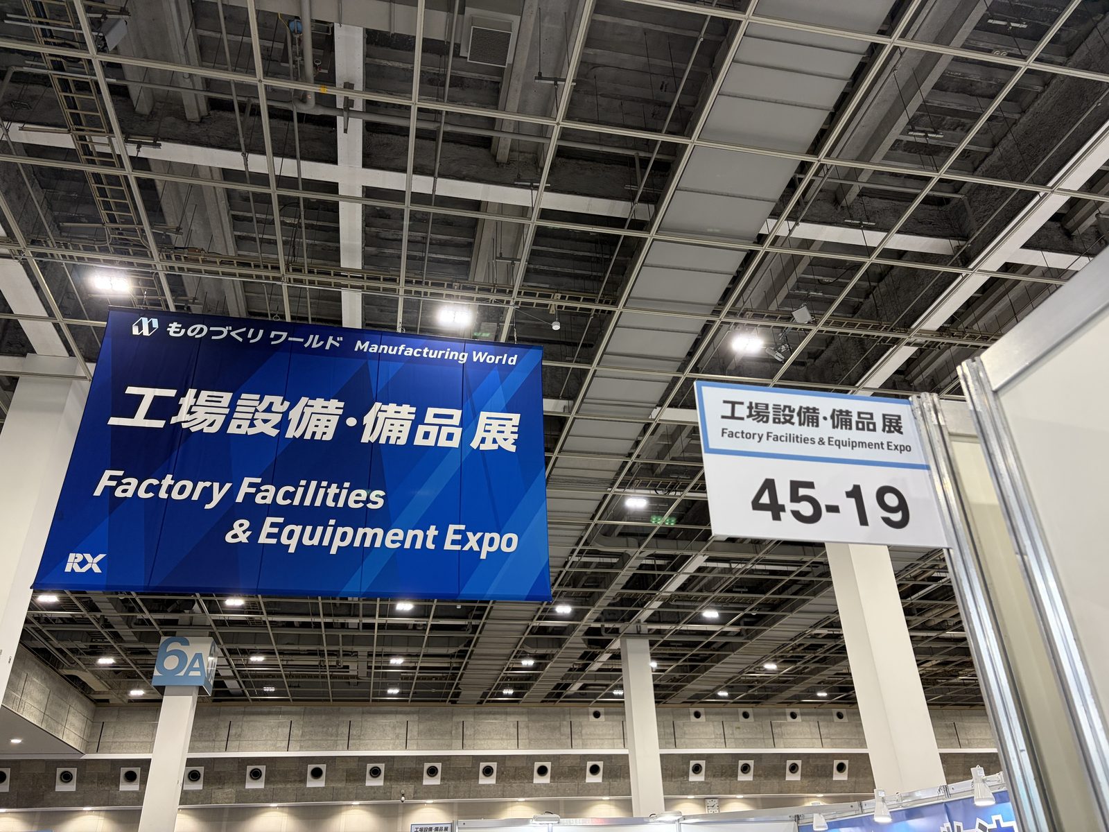 6号館の天井に下がる工場設備・備品展の看板と、小間番号 45-19 の札